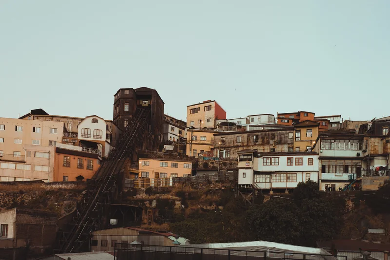 Hillside buildings and steep railway tracks beneath a pale blue sky.
